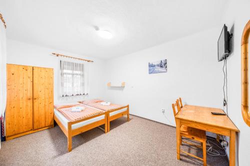 a room with a bed and a table and a desk at Ubytování u Foltýnů - Zelená Lhota in Nýrsko