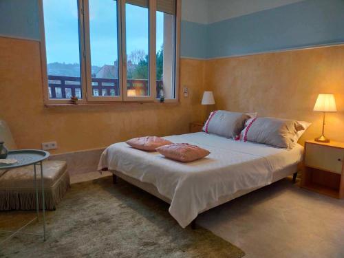 une chambre avec un lit avec deux oreillers dessus dans l'établissement Maison Bonhomme, à Cusset