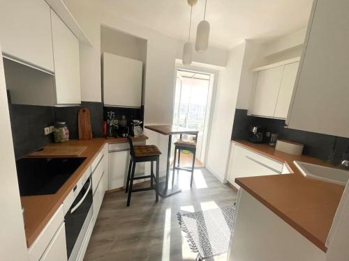 une cuisine avec des armoires blanches et une table et des chaises dans l'établissement Superbe appartement proche vélodrome et de la mer, à Marseille