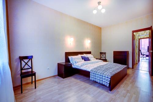 a bedroom with a bed and a chair in it at Welcome Home Apts Ligovsky 123 in Saint Petersburg