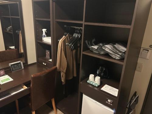 a room with a desk and a closet at Dormy Inn Express Koriyama in Koriyama