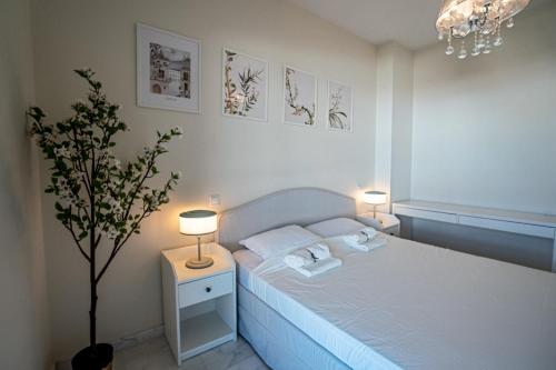 a bedroom with a bed with two lamps and a tree at Hello Cosmo in Estepona