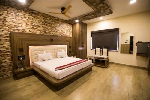 HisārにあるTheJewelHotelの大きなベッドと薄型テレビのある寝室