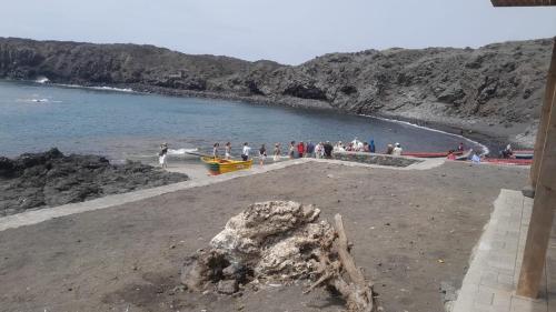 a group of people on a beach near the water at Pensao Zé Doce in Portela
