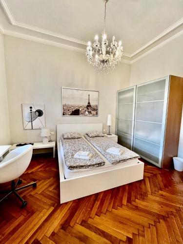 a bedroom with a bed and a chandelier at Four reasons apartment in Prague