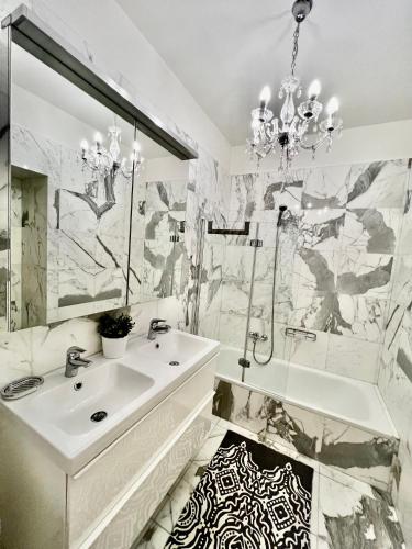 a white bathroom with a sink and a mirror at Four reasons apartment in Prague