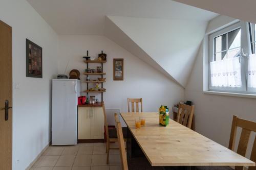 a kitchen with a wooden table and a refrigerator at Ubytovanie Eva in Oščadnica