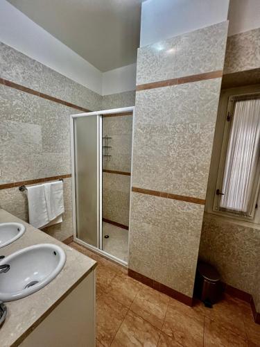 a bathroom with two sinks and a shower at Four reasons apartment in Prague