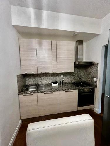 a kitchen with white cabinets and a stove top oven at Four reasons apartment in Prague