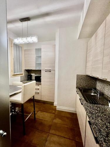 a kitchen with white cabinets and a table with a chair at Four reasons apartment in Prague