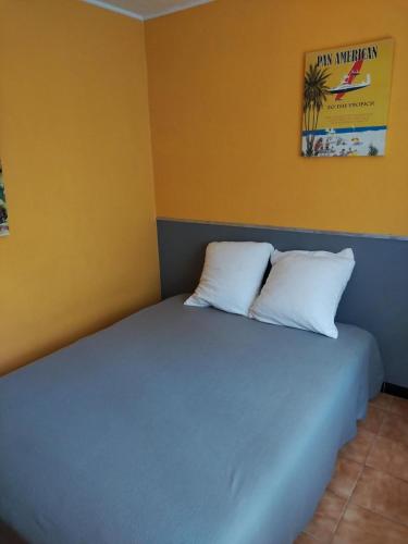 un lit dans une chambre avec deux oreillers dessus dans l'établissement CANET PLAGE Sud, à Canet