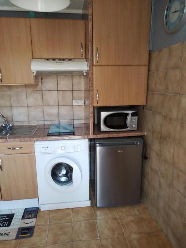 une cuisine avec un lave-linge et un micro-ondes dans l'établissement CANET PLAGE Sud, à Canet