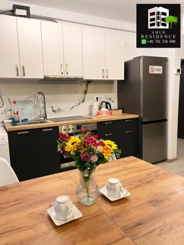 a kitchen with a wooden table with a vase of flowers at AmurResidence 64 Sauna Parking Barbeque in Iaşi