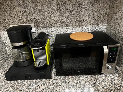 a microwave sitting on a counter next to a coffee maker at Four reasons apartment in Prague