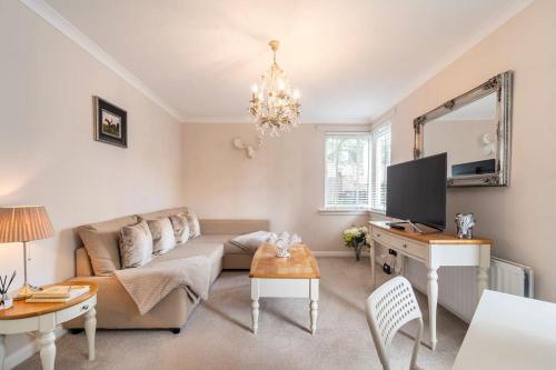 a living room with a couch and a tv at Immaculate City Centre Apartment with Free Parking - Ground Floor in Aberdeen