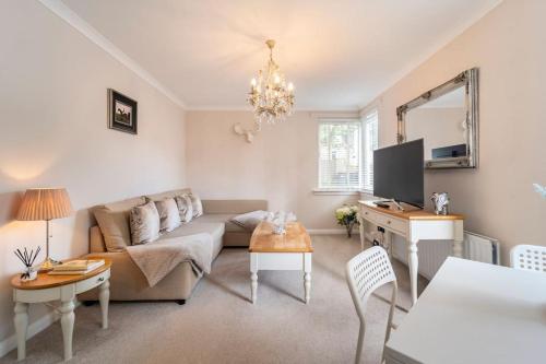 a living room with a couch and a tv at Immaculate City Centre Apartment with Free Parking - Ground Floor in Aberdeen