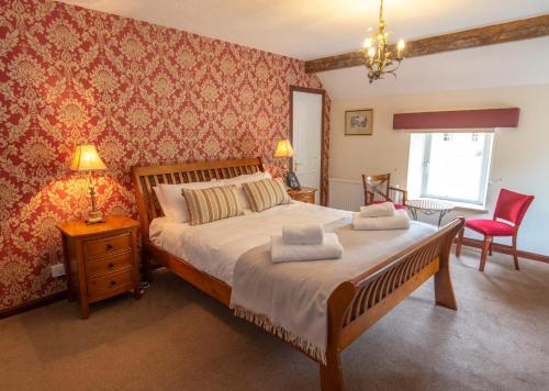 a bedroom with a bed with two towels on it at Saplinbrae Hotel and Lodges in Mintlaw