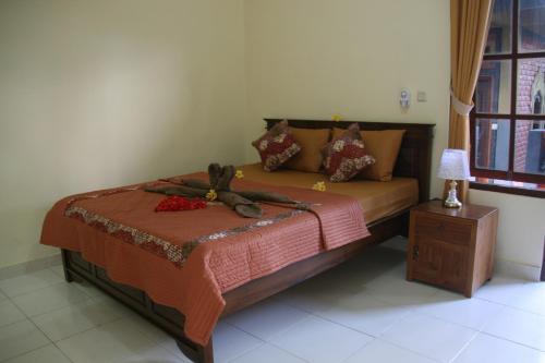 1 dormitorio con 1 cama y 1 mesa con lámpara en Santun Homestay en Ubud