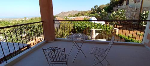 a balcony with two chairs and a table on it at Summer Villa with sea view,6 min drive from airport, near Seitan Limania beach in Khordhákion