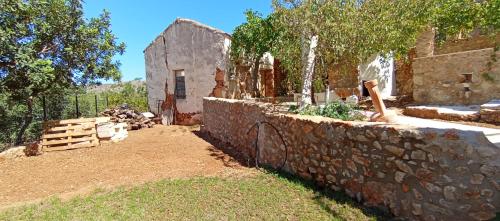 a stone retaining wall with a fountain in a yard at Summer Villa with sea view,6 min drive from airport, near Seitan Limania beach in Khordhákion
