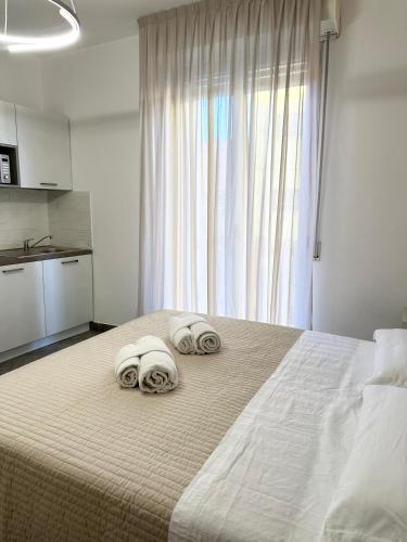 a bedroom with a large bed with towels on it at Residence Rimini Relax in Rimini