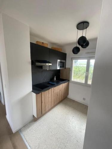 une cuisine avec comptoirs noirs et une fenêtre dans l'établissement Maison au cœur du vignoble, à Le Mesnil-sur-Oger