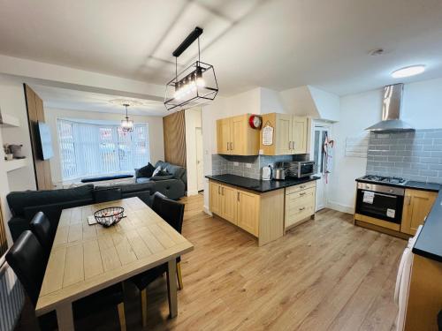 a kitchen and living room with a couch and a table at Numero Venti Aparthouse wifi parking Hot Tub in Newcastle upon Tyne