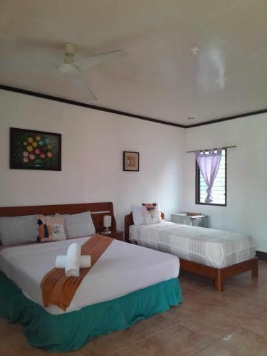 a bedroom with two beds and a window at Bonita Oasis Beach Resort in Moalboal