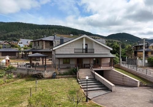a house with a hill in the background at La casa de Canedo in Arganza