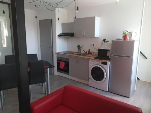a kitchen with a washer and dryer in a room at F1 en duplex coquelicot in Lamalou-les-Bains