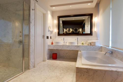 a bathroom with two sinks and a tub and a mirror at Buenos Aires Marriott in Buenos Aires