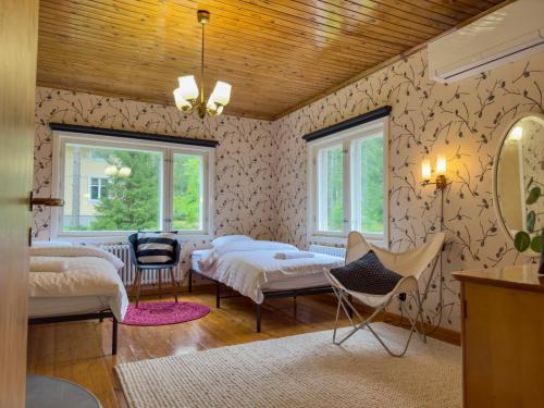 a bedroom with two beds and a mirror at Arctic Garden Design Villa in Rovaniemi