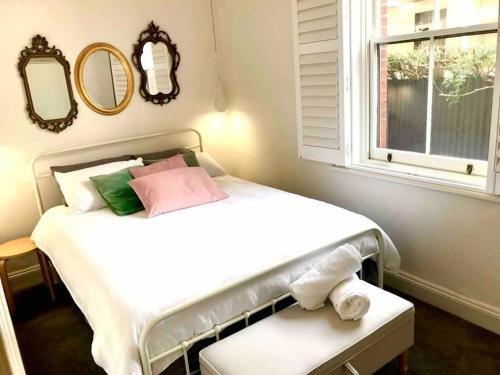 グレネルグにあるThe Beach Cottage Nookの窓と鏡付きの部屋のベッド1台分です。