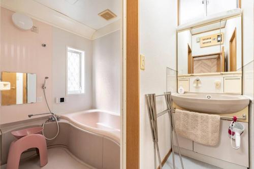 y baño con bañera rosa y lavamanos. en 柴又1丁目, en Tokio
