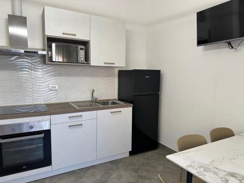 a kitchen with a sink and a black refrigerator at Residence Rimini Relax in Rimini