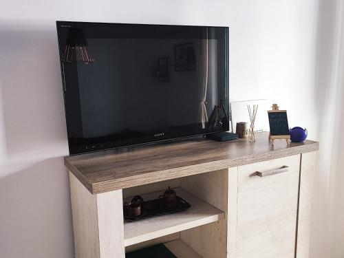 duży telewizor z płaskim ekranem w drewnianym centrum rozrywki w obiekcie Apartman Bulevar, Sarajevo w Sarajewie