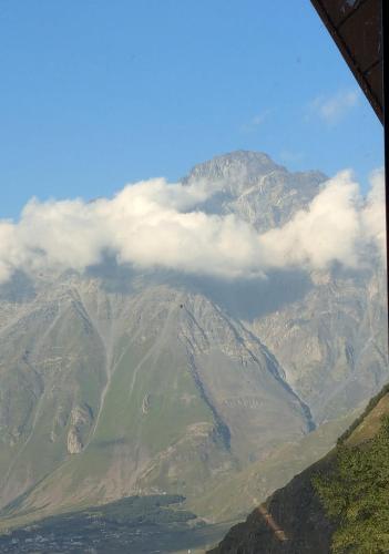 a view of a mountain with clouds over it at Rest point cottage Kazbegi in Stepantsminda