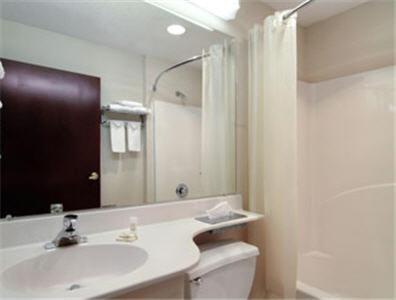 a bathroom with a sink and a toilet and a mirror at Stay Express inn and Suites Atlanta Union City in Union City