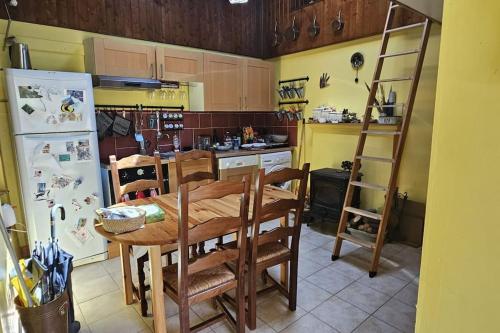 une cuisine avec une table en bois et un réfrigérateur dans l'établissement Maison cosy à la montagne, à La Chalp