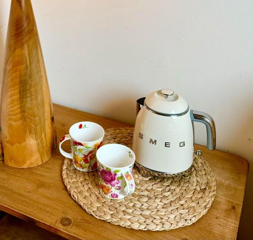 - une table avec deux tasses et une théière dans l'établissement Nid douillet Les Mouettes, à Fouesnant