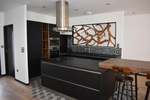 cocina con encimera negra y mesa en superbe villa neuve, en Aytré