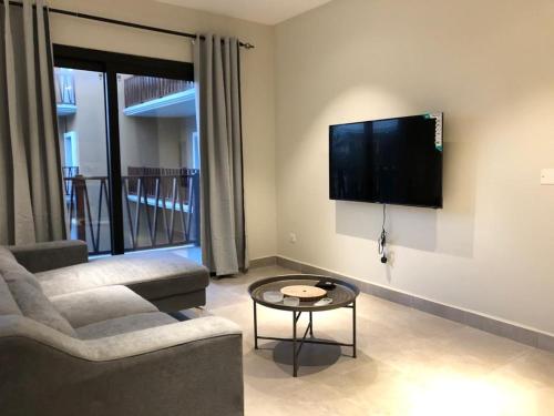 a living room with a couch and a flat screen tv at Forest View Apartments in Kololi
