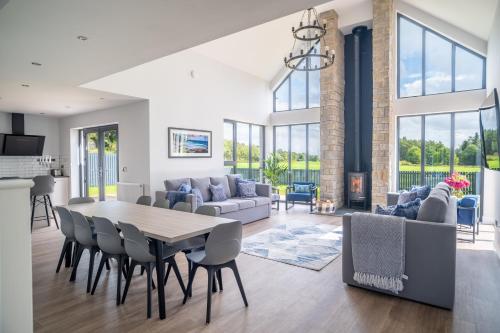 a dining room and living room with a table and chairs at Lowwood Lodges in Houston