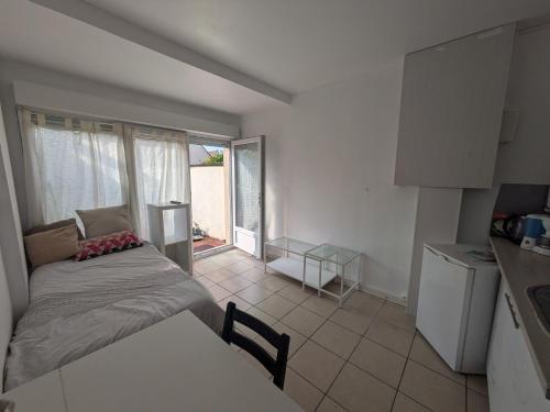 une petite chambre avec un lit et une cuisine dans l'établissement Nature Shot - DisneyLand Roissy, à Chauconin