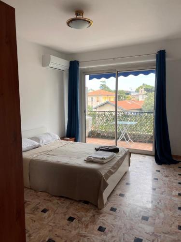 une chambre avec un lit et une grande fenêtre dans l'établissement Grand appartement proche Promenade, à Nice