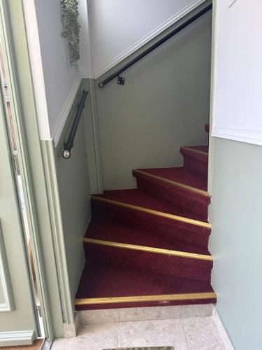 a staircase in a house with red carpet at Maison de ville 65 m2 Proche Paris in Alfortville