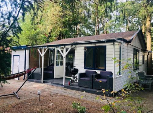 a white tiny house with a porch and a patio at Forest Cottage Hattem in Hattemerbroek