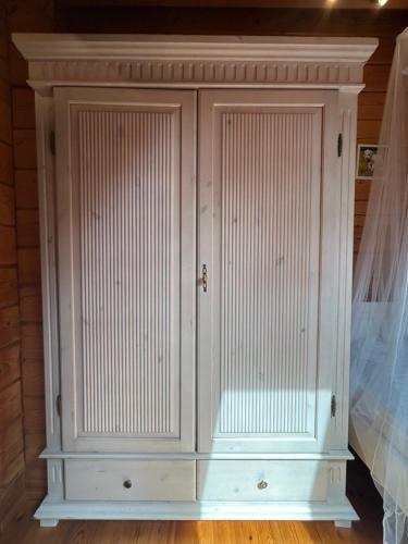 a white cabinet with two doors in a bedroom at Villa Easy Living in Bierzwnik