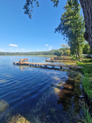 a dock in the middle of a lake at Villa Easy Living in Bierzwnik