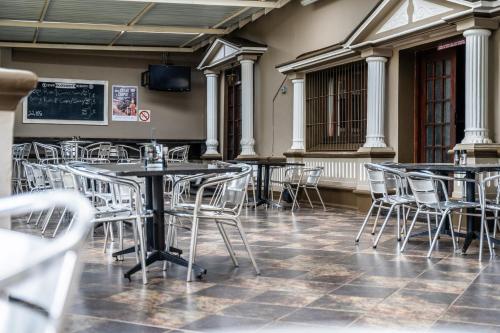 a restaurant with tables and chairs and a chalkboard at ATKV Buffelspoort in Rustenburg